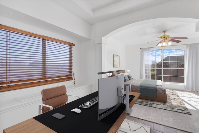 office space with arched walkways and ceiling fan