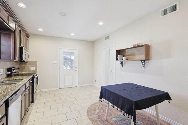 632 E Main, Pilot Point, TX 76258 - kitchen featuring a sink, appliances with stainless steel finishes, light stone countertops, and visible vents