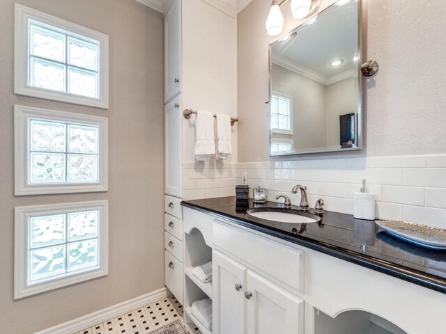 1410 Corto Dr, Dallas, TX 75218 - bathroom featuring crown molding, vanity, baseboards, and decorative backsplash
