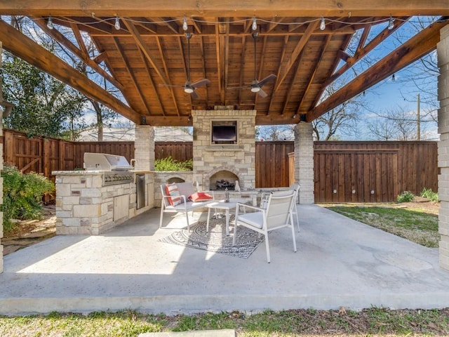 1410 Corto Dr, Dallas, TX 75218 - fenced backyard featuring an outdoor stone fireplace, a patio area, and a ceiling fan