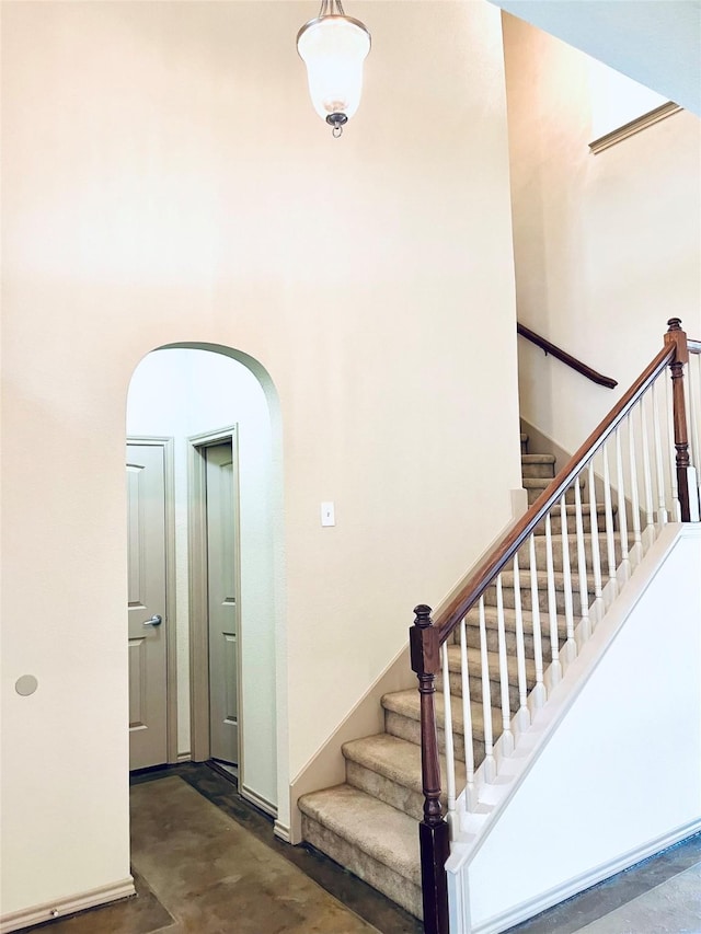 1209 Kachina Ln, Fort Worth, TX 76052 - stairway featuring concrete floors, arched walkways, and a high ceiling