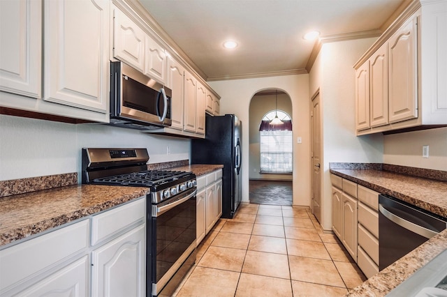 1209 Kachina Ln, Fort Worth, TX 76052 - kitchen with appliances with stainless steel finishes, ornamental molding, arched walkways, dark countertops, and light tile patterned flooring