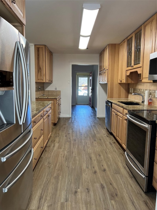 6904 Glenwood Dr, North Richland Hills, TX 76182 - kitchen featuring appliances with stainless steel finishes, wood finished floors, a sink, baseboards, and glass insert cabinets