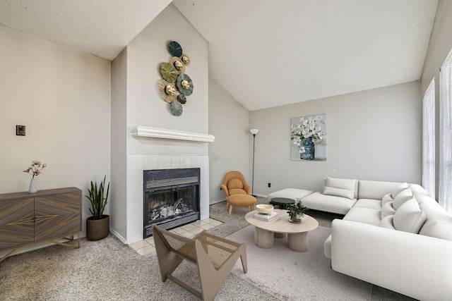 living area featuring a tile fireplace, lofted ceiling, and carpet flooring