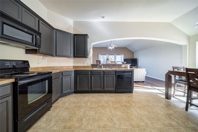 kitchen with black appliances, a peninsula, a ceiling fan, and vaulted ceiling