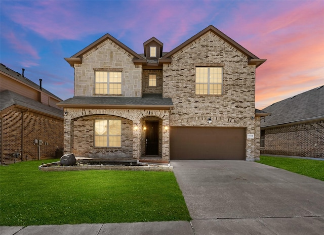 3608 Helm Ln, Denton, TX 76210 - french country style house featuring an attached garage, a yard, concrete driveway, and brick siding