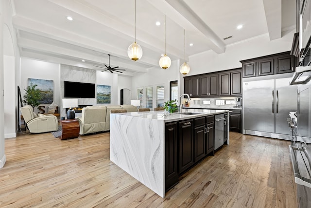 504 Shadow Wood Ln, Heath, TX 75032 - kitchen featuring stainless steel appliances, a sink, beamed ceiling, ceiling fan, and light wood-style floors
