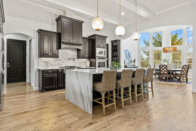 504 Shadow Wood Ln, Heath, TX 75032 - kitchen with stainless steel appliances, a high ceiling, beam ceiling, light wood finished floors, and decorative backsplash