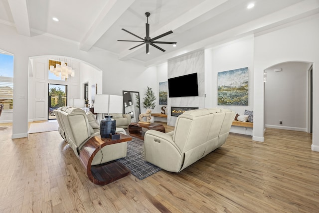 504 Shadow Wood Ln, Heath, TX 75032 - living area featuring arched walkways, light wood-style floors, beamed ceiling, a premium fireplace, and recessed lighting