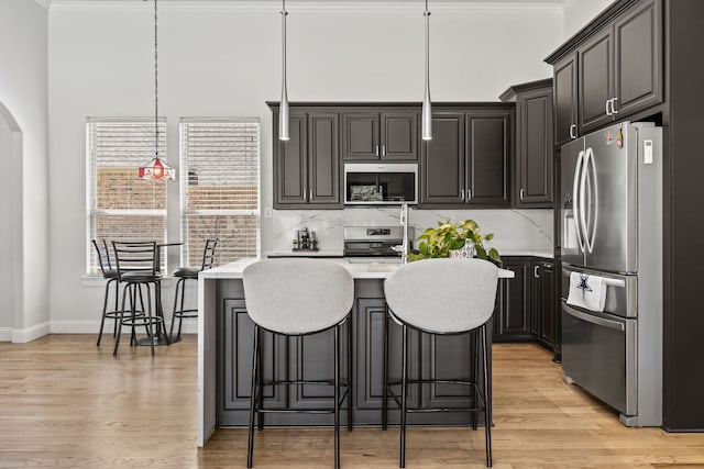 504 Shadow Wood Ln, Heath, TX 75032 - kitchen with appliances with stainless steel finishes, ornamental molding, light countertops, light wood-style floors, and backsplash