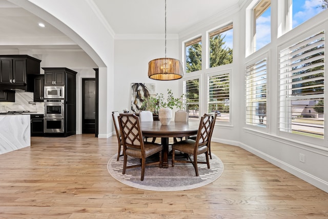 504 Shadow Wood Ln, Heath, TX 75032 - dining space featuring healthy amount of natural light, light wood-type flooring, baseboards, ornamental molding, and arched walkways