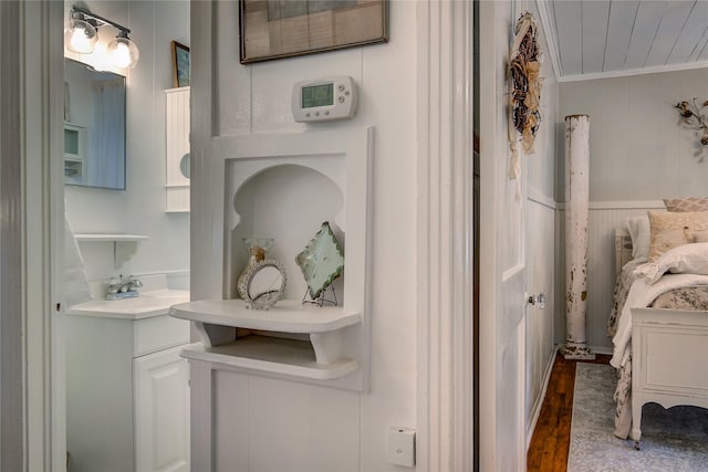 bathroom with crown molding and wood finished floors