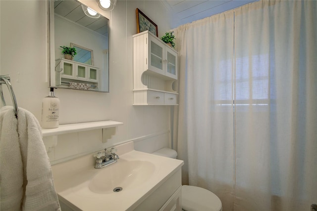 bathroom with vanity, toilet, and crown molding