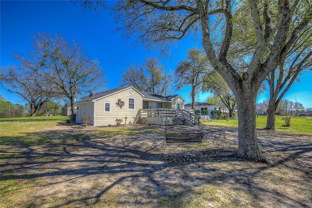 view of front of property with a front lawn, a wooden deck, and stairway
