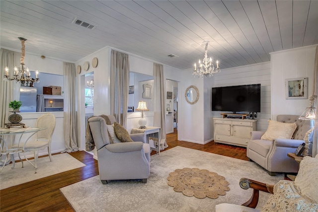 living area with visible vents, wood finished floors, a chandelier, and wood ceiling