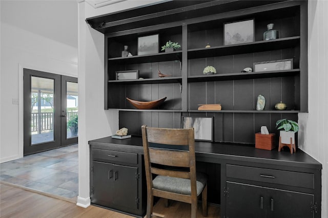 office featuring french doors, built in shelves, light wood-style floors, and built in study area