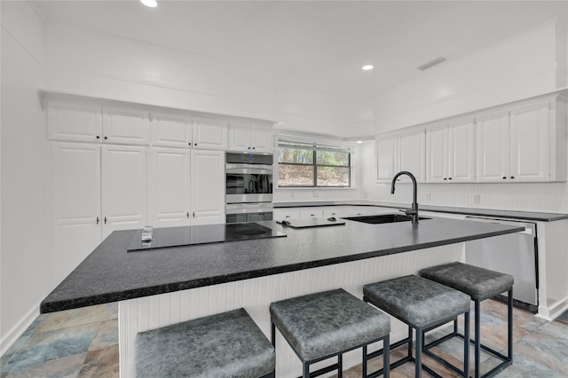 kitchen with visible vents, white cabinets, stainless steel appliances, and a sink