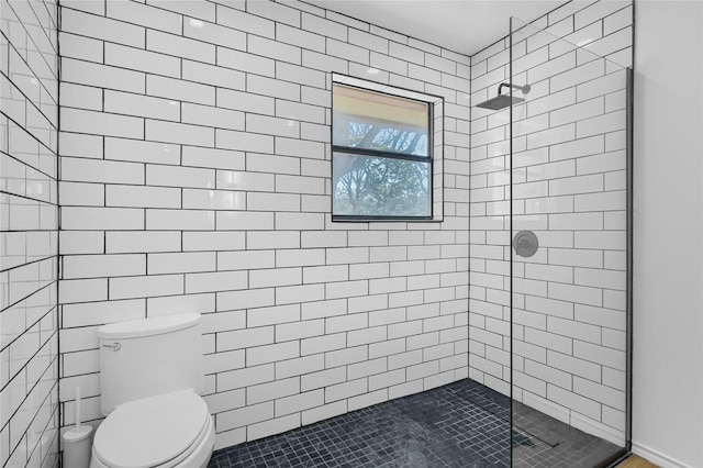full bath with toilet and tiled shower