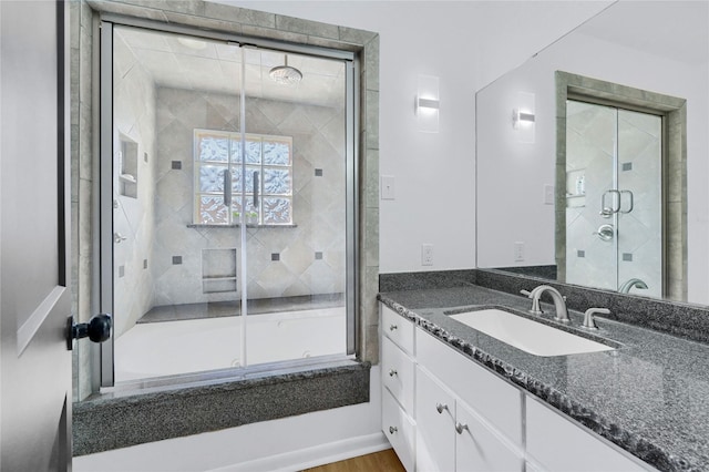 full bath featuring vanity and combined bath / shower with glass door