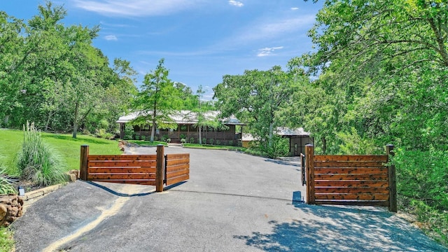 view of gate featuring a lawn and fence