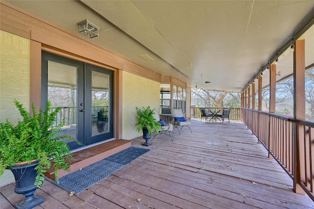 wooden terrace featuring outdoor dining space and french doors