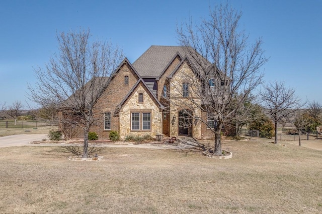1211 Meredith Creek Ln, Fort Worth, TX 76179 - french country inspired facade with a front lawn, stone siding, and roof with shingles