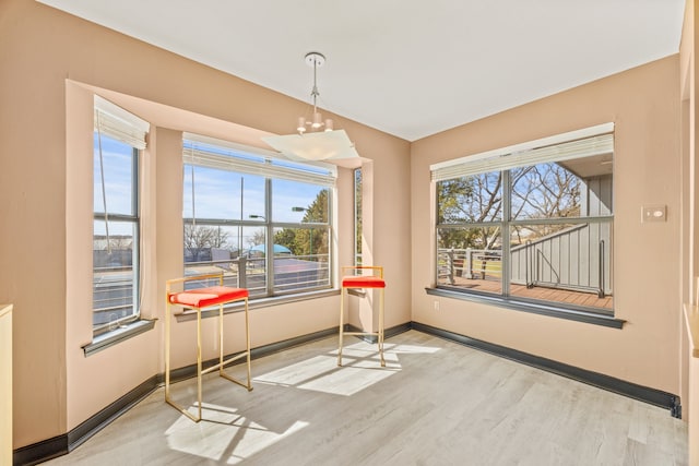 dining space featuring a notable chandelier, wood finished floors, and baseboards
