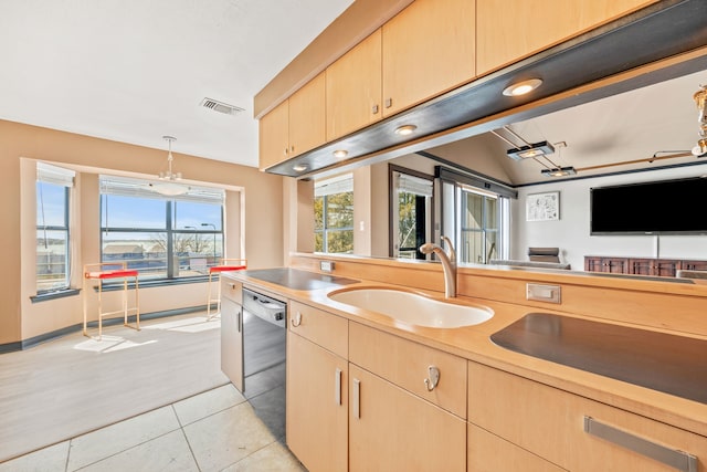 kitchen with dishwashing machine, visible vents, a sink, light brown cabinetry, and light countertops