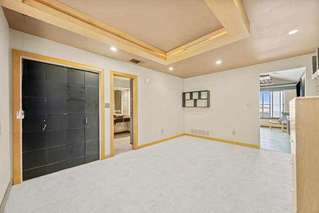 interior space with a tray ceiling, visible vents, and baseboards