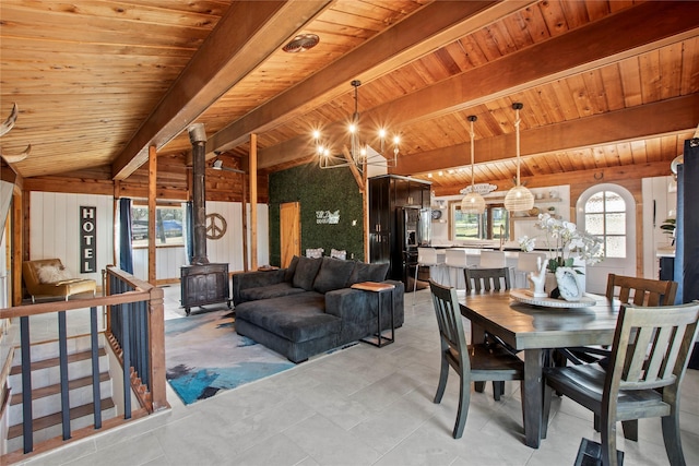 104 Henderson Harbor Cir, Payne Springs, TX 75156 - dining room with a wood stove, a chandelier, wooden ceiling with exposed beams, and wooden walls