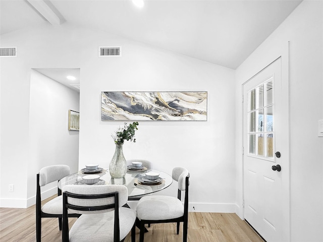 dining space featuring visible vents, lofted ceiling with beams, baseboards, and light wood-type flooring