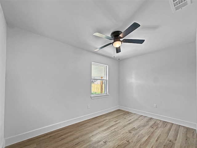 spare room featuring baseboards, light wood finished floors, and visible vents