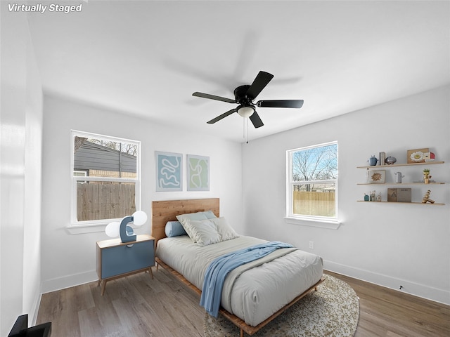 bedroom with baseboards, ceiling fan, and wood finished floors