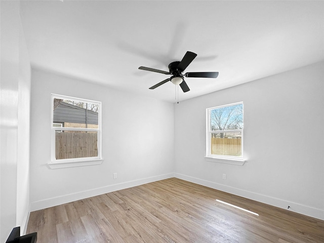 spare room featuring baseboards, ceiling fan, and wood finished floors