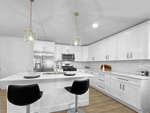 kitchen featuring light countertops, tasteful backsplash, light wood-type flooring, stainless steel appliances, and a sink