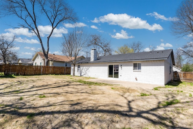1505 W Collin, Corsicana, TX 75110 - back of property featuring brick siding, fence, a chimney, and a patio area
