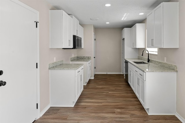 1505 W Collin, Corsicana, TX 75110 - kitchen featuring a sink, baseboards, recessed lighting, wood finished floors, and white cabinetry