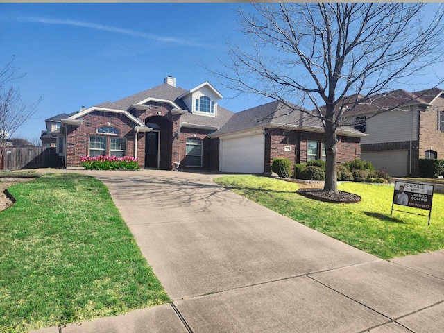 view of front facade featuring concrete driveway, fence, brick siding, a garage, and a front yard