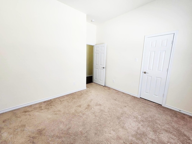 carpeted empty room with baseboards