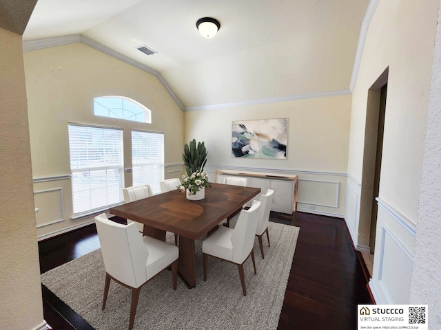 dining space with lofted ceiling, a wainscoted wall, dark wood-style floors, visible vents, and ornamental molding
