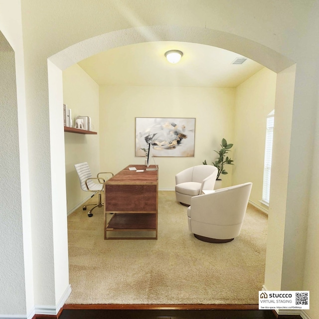 sitting room featuring arched walkways, visible vents, and carpet floors