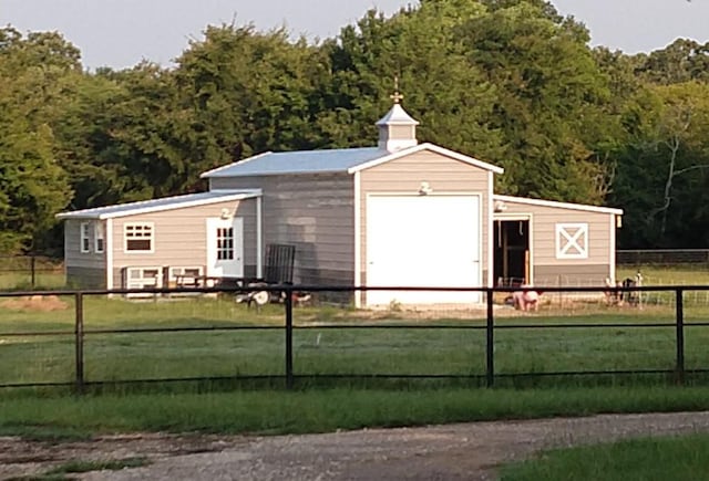 view of outbuilding with an outdoor structure, fence private yard, and a wooded view