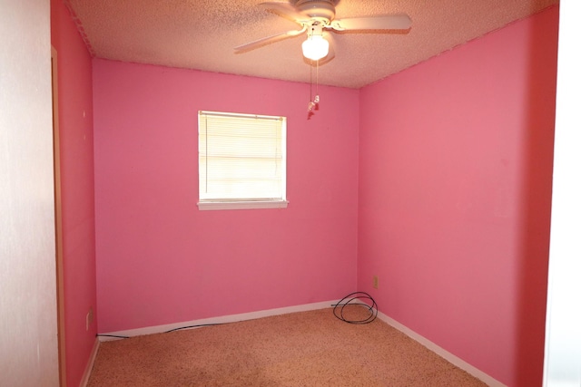carpeted spare room with baseboards, a ceiling fan, and a textured ceiling