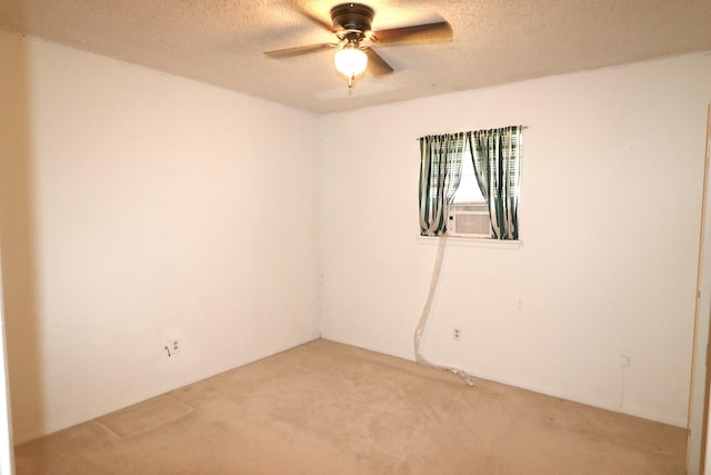spare room with cooling unit, light carpet, a textured ceiling, and ceiling fan