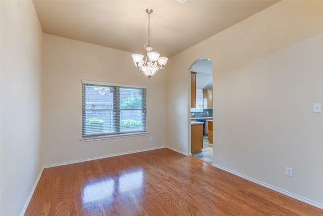 1032 Bending Oak Dr, Cedar Hill, TX 75104 - empty room with light wood-style floors, arched walkways, a chandelier, and baseboards