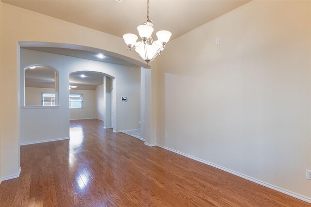 1032 Bending Oak Dr, Cedar Hill, TX 75104 - empty room featuring a chandelier, arched walkways, wood finished floors, and baseboards