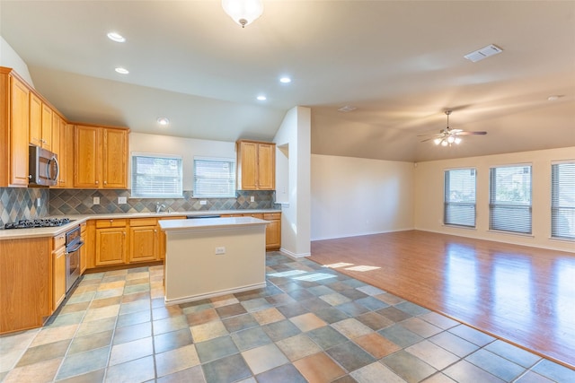 1032 Bending Oak Dr, Cedar Hill, TX 75104 - kitchen with stainless steel microwave, vaulted ceiling, light countertops, tasteful backsplash, and a kitchen island