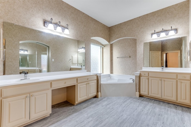 12252 Skipper Dr, Frisco, TX 75035 - bathroom featuring a bath, two vanities, wood finished floors, and healthy amount of natural light