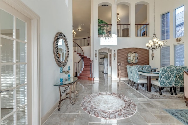 12252 Skipper Dr, Frisco, TX 75035 - entryway with a chandelier, arched walkways, stairway, a towering ceiling, and baseboards