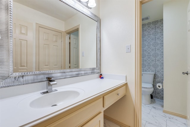 12252 Skipper Dr, Frisco, TX 75035 - bathroom with toilet, marble look tiles, vanity, and baseboards